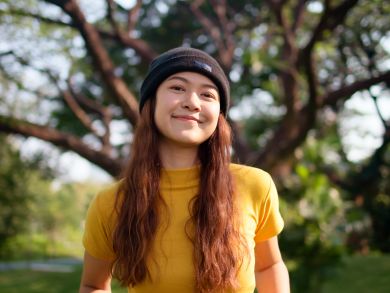 Frau mit Mütze Eine Frau mit Mütze steht in einem Park.