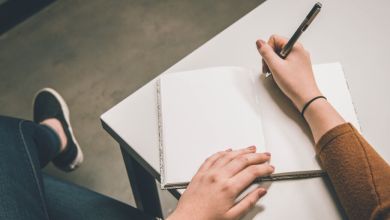 Notizbuch Ein Notizbuch liegt auf dem Tisch mit zwei Händen